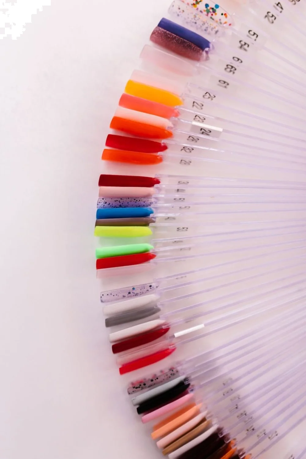Swatches of six summer nail polish shades on a nail wheel, showcasing various colors and finishes under natural light