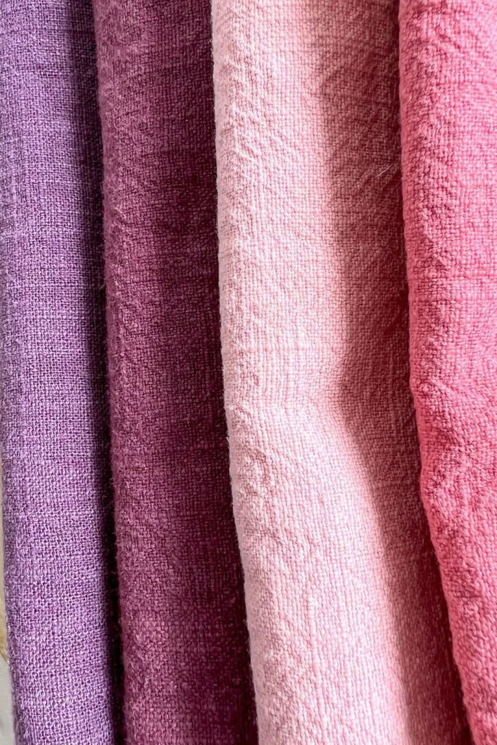 Four nail swatches in varying shades of purple and pink, showing different levels of tip wear and shine retention, best top c